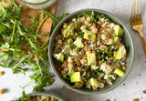 savory breakfast power bowl with quinoa white beans avocado arugula and seeds, plant based breakfast bowl with daily greens tahini sauce drizzle, healthy savoury breakfast bowl with pumpkin seeds and sliced avocado, 